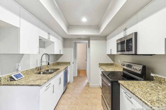 kitchen featuring a tray ceiling, white cabinetry, sink, and appliances with stainless steel finishes