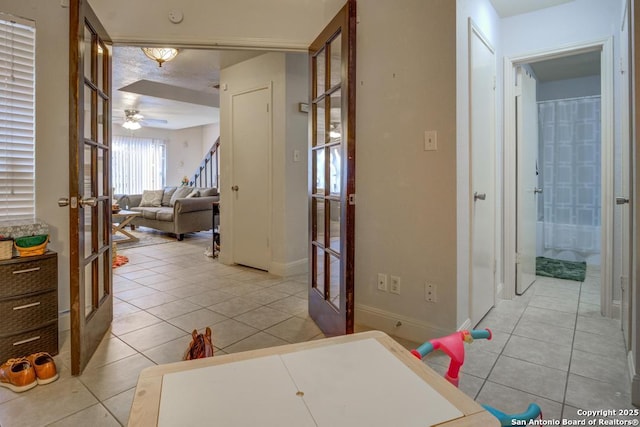 hallway featuring light tile patterned floors and french doors