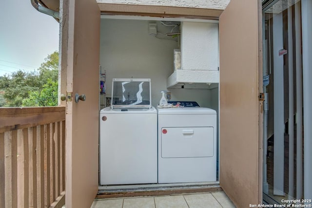 laundry area featuring washer and dryer and light tile patterned floors