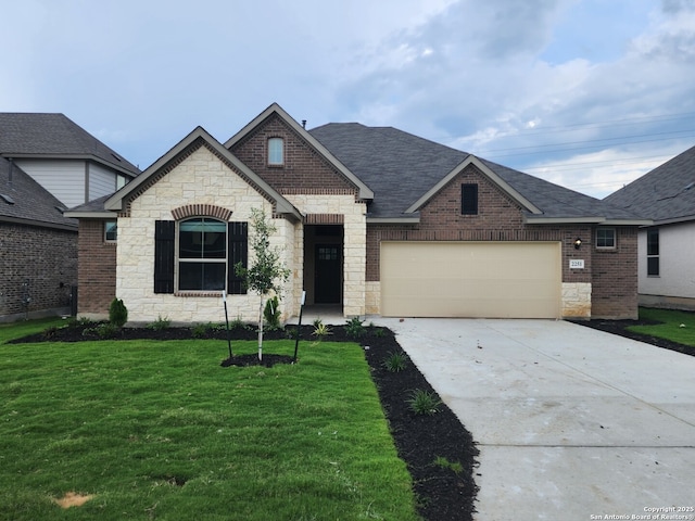 french country home with brick siding, roof with shingles, concrete driveway, a front yard, and a garage