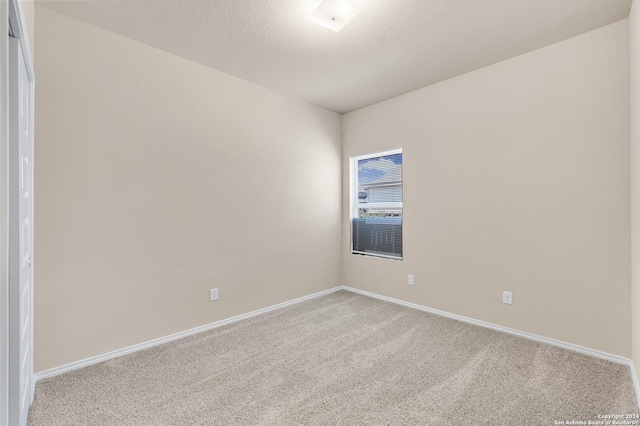 carpeted spare room with a textured ceiling