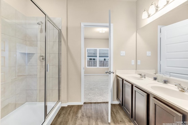 bathroom featuring vanity, an enclosed shower, and wood-type flooring