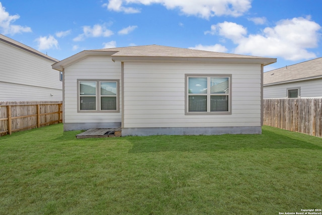 rear view of property featuring a yard