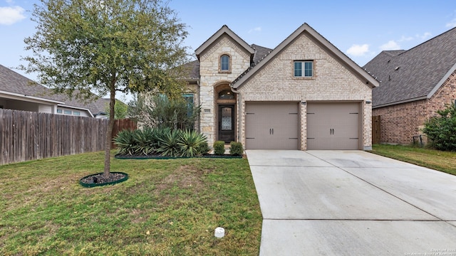 french provincial home with a front yard and a garage