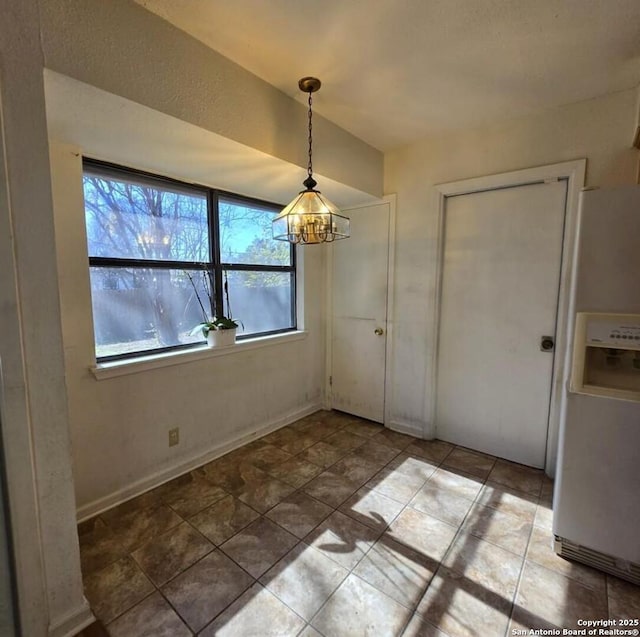 unfurnished dining area featuring a chandelier