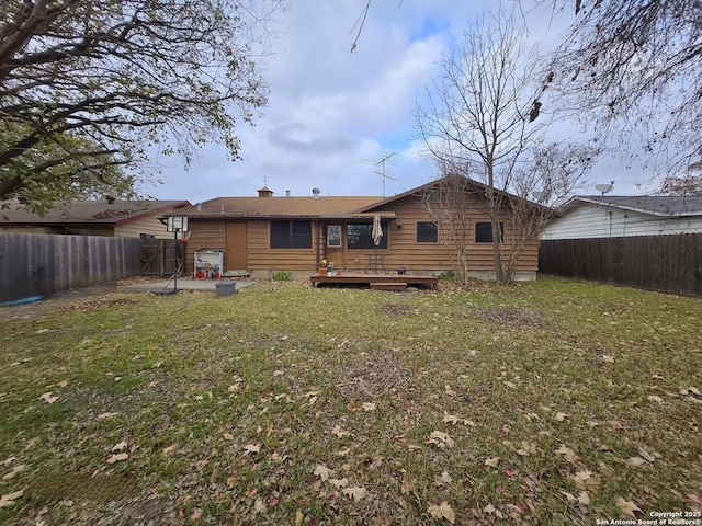 rear view of house featuring a lawn and a deck