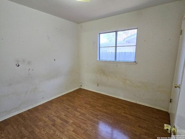 empty room with dark hardwood / wood-style flooring