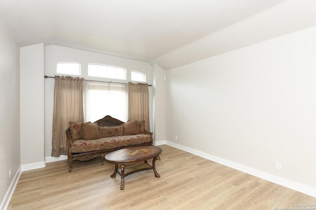 living area with light wood-type flooring and vaulted ceiling