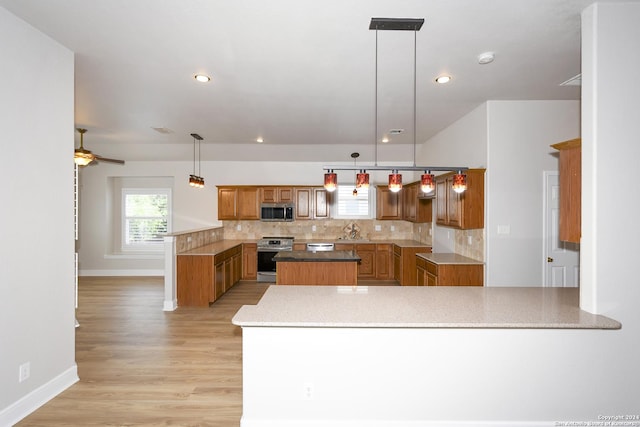 kitchen featuring pendant lighting, ceiling fan, kitchen peninsula, and stainless steel appliances