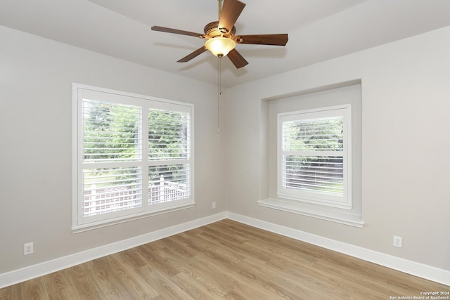 empty room with light hardwood / wood-style floors, ceiling fan, and a healthy amount of sunlight