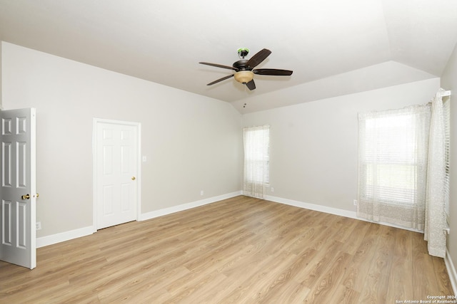 empty room featuring light wood-type flooring, vaulted ceiling, and ceiling fan