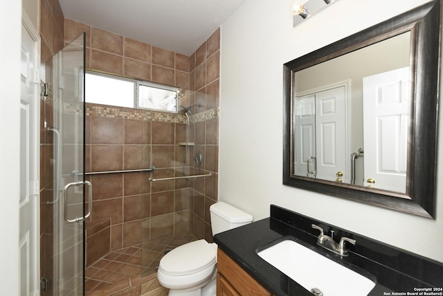 bathroom featuring vanity, toilet, and an enclosed shower