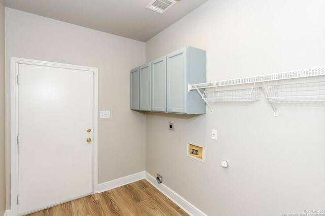 laundry area featuring electric dryer hookup, cabinets, hookup for a gas dryer, light hardwood / wood-style flooring, and washer hookup