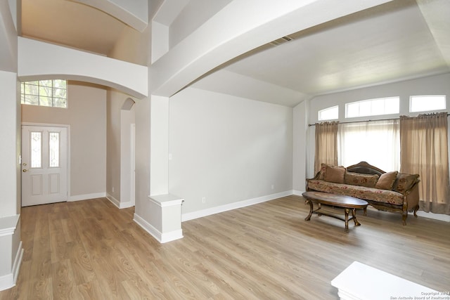 foyer entrance with light wood-type flooring and high vaulted ceiling