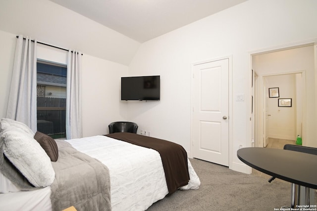 bedroom with light carpet and lofted ceiling