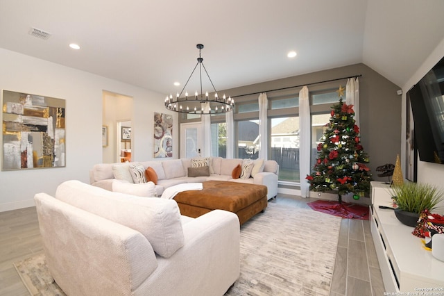 living room with vaulted ceiling and an inviting chandelier