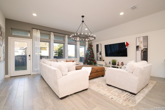 living room featuring a notable chandelier and light wood-type flooring