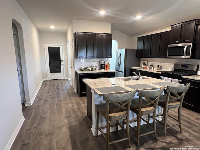 kitchen featuring decorative backsplash, sink, an island with sink, and appliances with stainless steel finishes