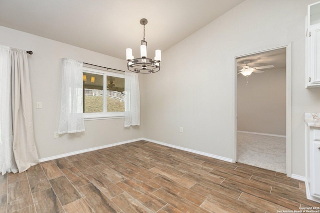 empty room with vaulted ceiling and ceiling fan with notable chandelier