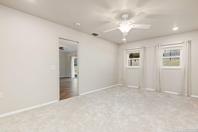 carpeted spare room with ceiling fan