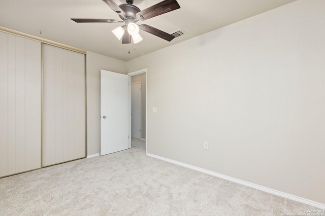 unfurnished bedroom featuring a closet, light carpet, and ceiling fan