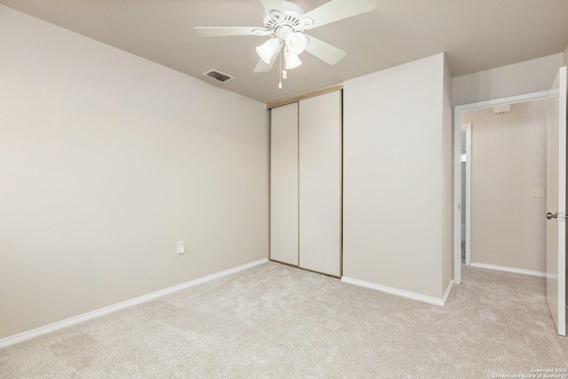 unfurnished bedroom featuring light carpet, a closet, and ceiling fan