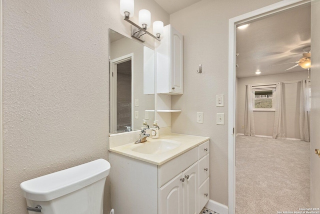 bathroom with toilet, ceiling fan, and vanity