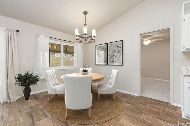 dining space with vaulted ceiling and ceiling fan with notable chandelier