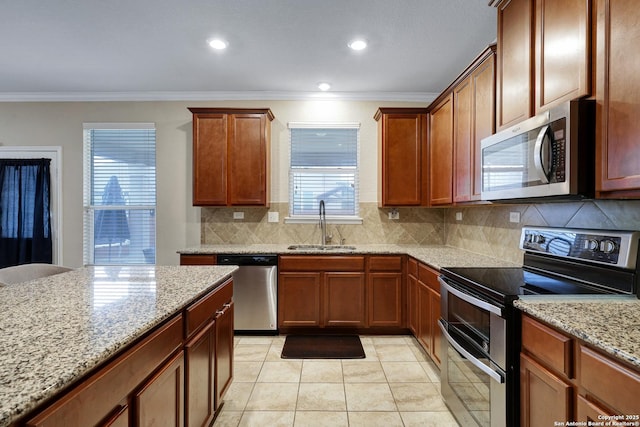 kitchen featuring light stone countertops, sink, stainless steel appliances, tasteful backsplash, and crown molding