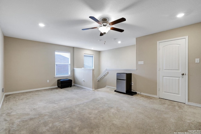 carpeted spare room with ceiling fan