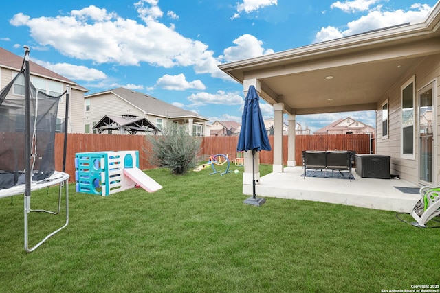 view of yard with central AC, a patio, and a trampoline