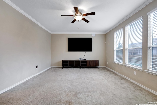 unfurnished living room featuring ceiling fan, carpet floors, and ornamental molding