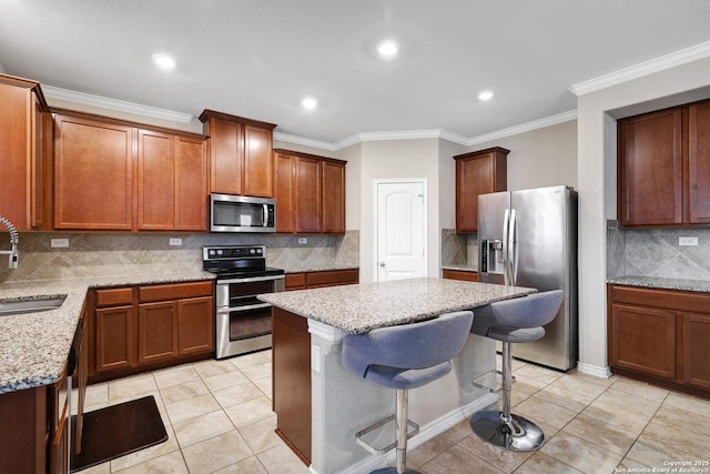 kitchen with stainless steel appliances, light stone counters, a breakfast bar area, light tile patterned floors, and ornamental molding