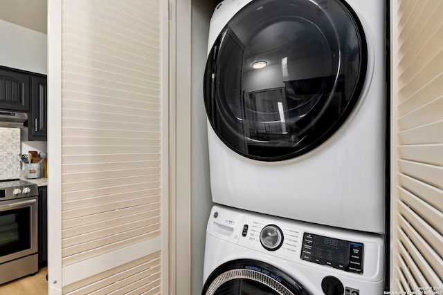 washroom featuring stacked washer and dryer and light hardwood / wood-style flooring