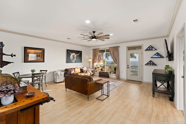 living room featuring ceiling fan, light hardwood / wood-style floors, and crown molding