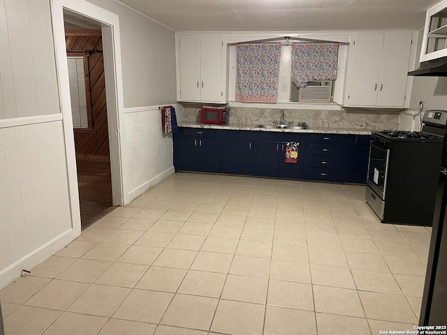 kitchen featuring gas range, white cabinetry, sink, and light tile patterned flooring