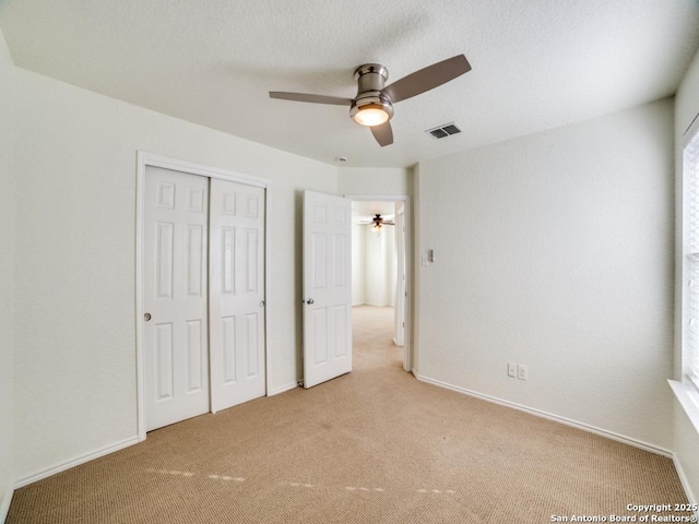 unfurnished bedroom with a closet, ceiling fan, and light colored carpet