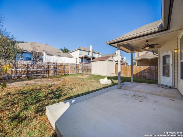 view of yard with a storage shed, ceiling fan, and a patio area