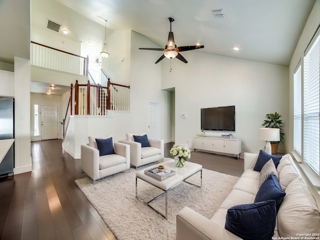 living room featuring a wealth of natural light, high vaulted ceiling, and dark hardwood / wood-style floors