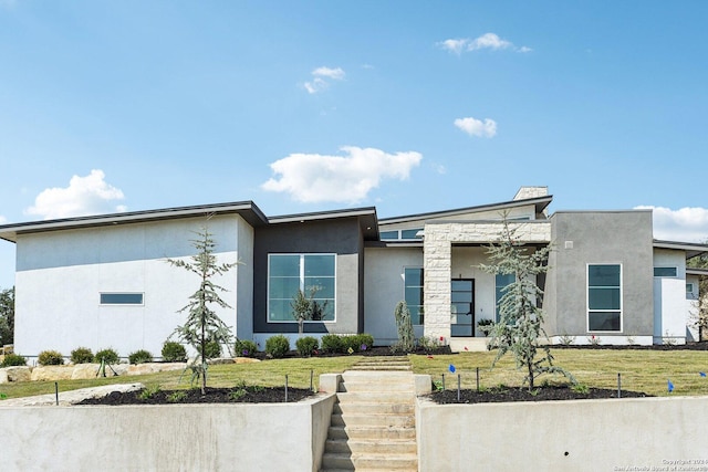 contemporary house featuring a front yard