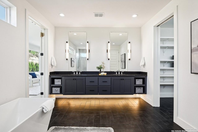 bathroom featuring a tub to relax in, vanity, and hardwood / wood-style flooring