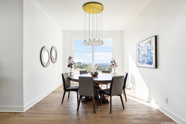 dining area featuring hardwood / wood-style floors and an inviting chandelier