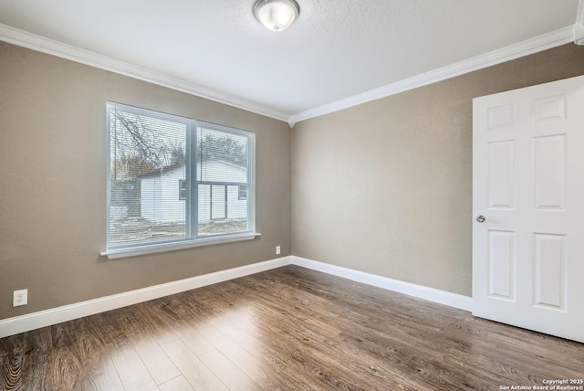 empty room with crown molding, wood-type flooring, and a textured ceiling