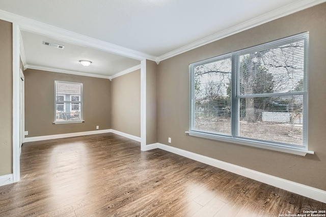 empty room featuring ornamental molding, dark wood-type flooring, and a wealth of natural light