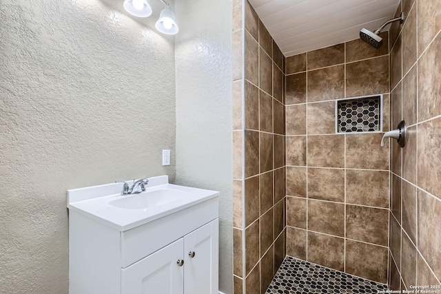 bathroom with vanity and tiled shower