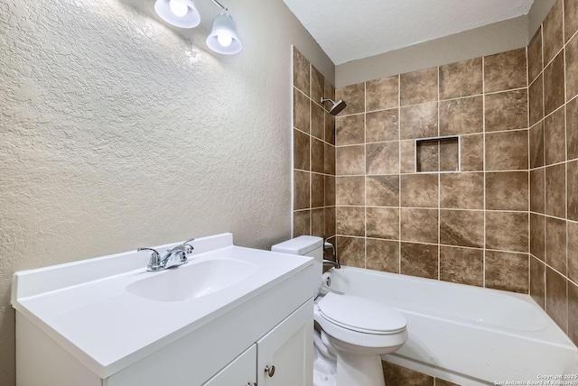 full bathroom with tiled shower / bath combo, toilet, a textured ceiling, and vanity