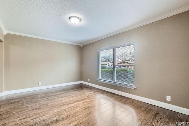 spare room featuring a textured ceiling, wood-type flooring, and crown molding