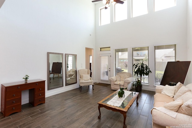 living room featuring ceiling fan, dark hardwood / wood-style flooring, and a towering ceiling