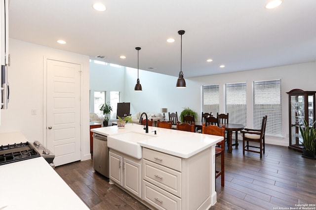 kitchen featuring white cabinetry, sink, dark wood-type flooring, stainless steel dishwasher, and a center island with sink