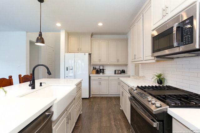 kitchen with decorative backsplash, appliances with stainless steel finishes, dark hardwood / wood-style flooring, sink, and hanging light fixtures